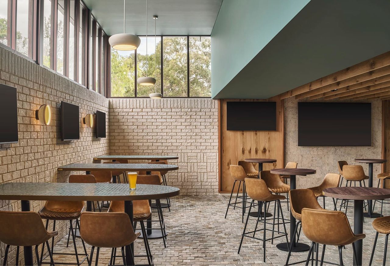 SPORTS LOUNGE WITH LARGE TREE-LINED WINDOWS