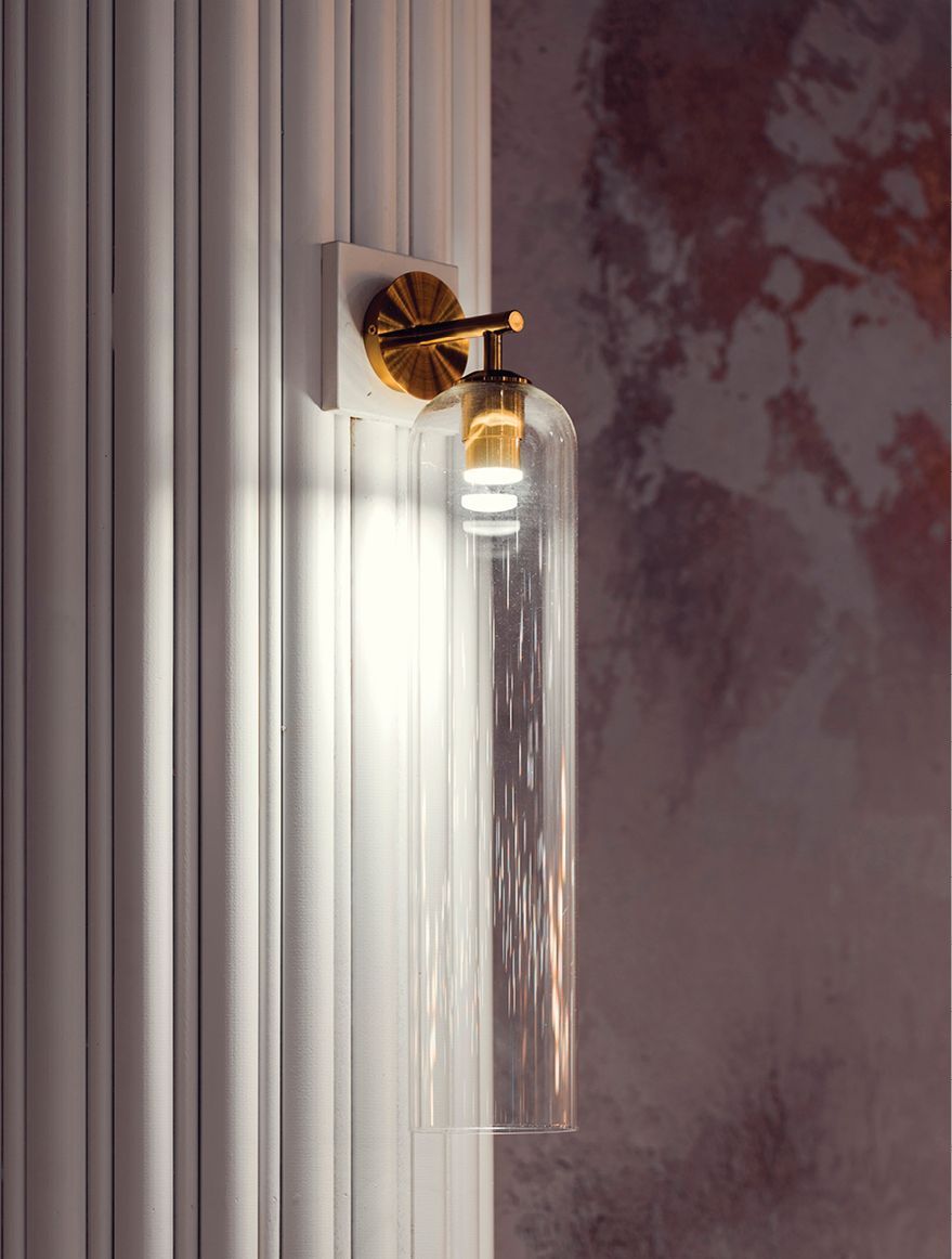 Wall sconce adorned columns and white fluted marble bar